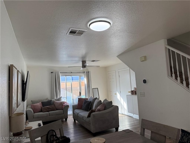 living room featuring a textured ceiling, ceiling fan, and hardwood / wood-style flooring