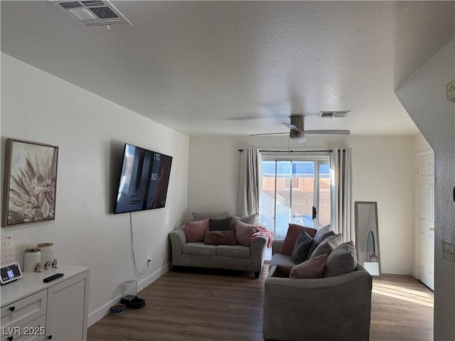 living room featuring a textured ceiling, ceiling fan, and wood-type flooring