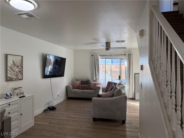 living room featuring a textured ceiling, ceiling fan, and hardwood / wood-style floors