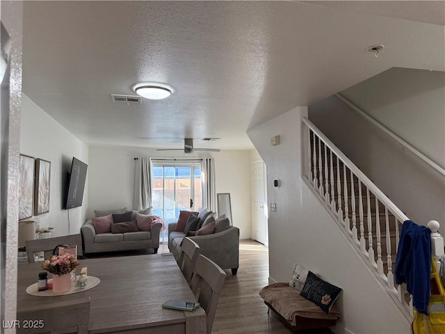 dining area with a textured ceiling, ceiling fan, and hardwood / wood-style floors