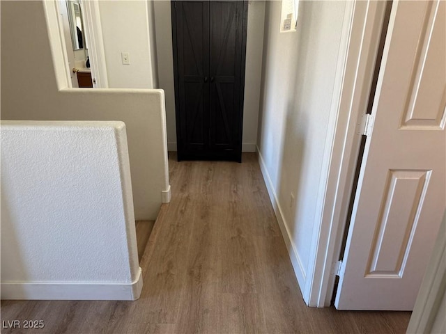 hallway with light hardwood / wood-style floors