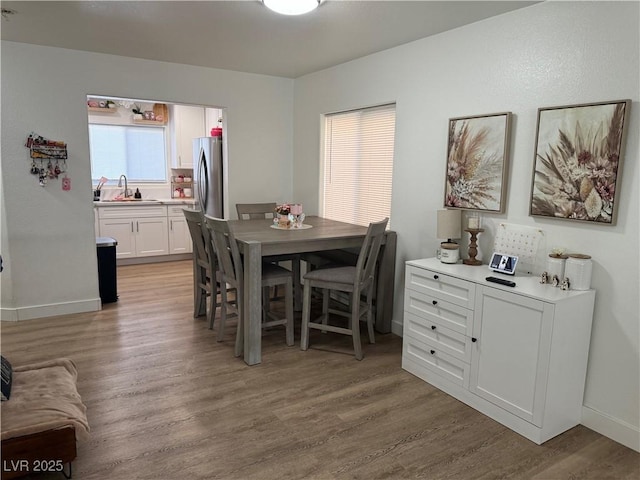 dining area with sink and light hardwood / wood-style flooring