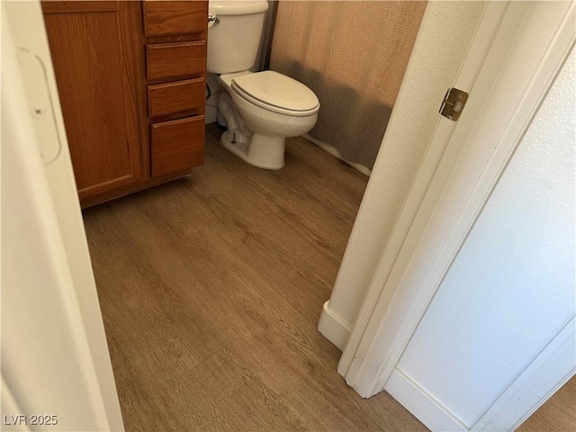 bathroom with toilet and wood-type flooring