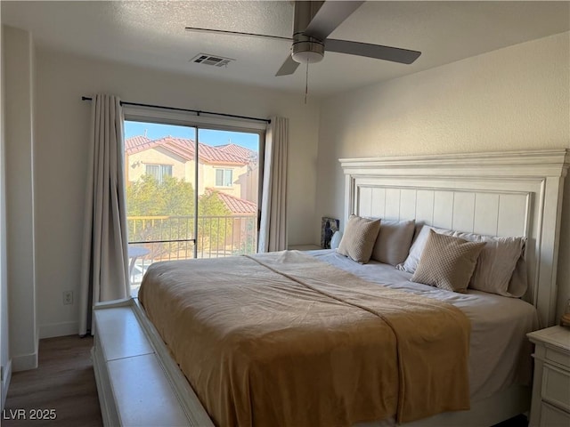 bedroom featuring ceiling fan, access to outside, a textured ceiling, and wood-type flooring