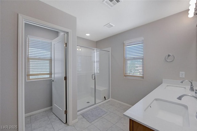 bathroom with tile patterned flooring, a shower with door, and vanity