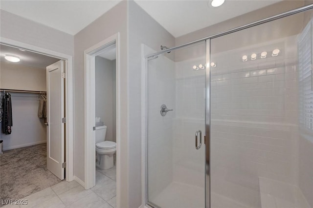 bathroom featuring toilet, an enclosed shower, and tile patterned flooring