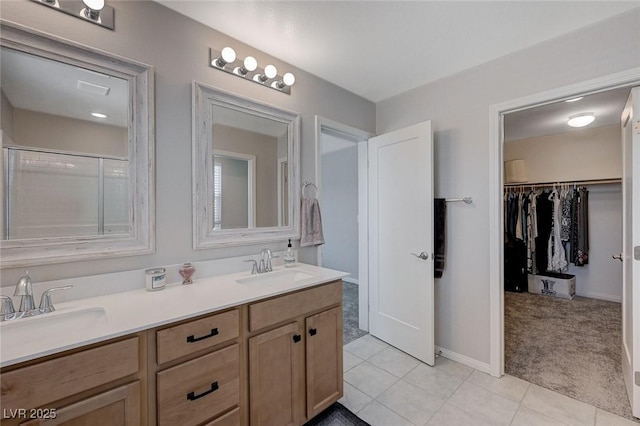 bathroom with a shower with door, vanity, and tile patterned floors