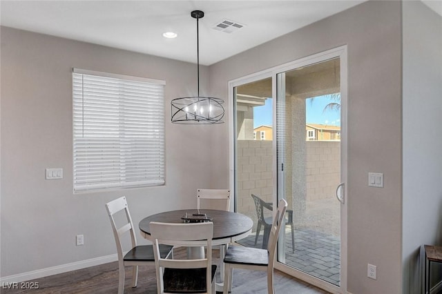 dining space with a chandelier and wood-type flooring