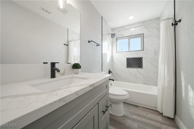 full bathroom featuring shower / bathtub combination with curtain, hardwood / wood-style floors, vanity, and toilet