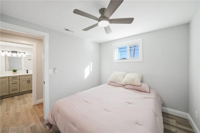 bedroom with ensuite bathroom, ceiling fan, and light hardwood / wood-style flooring