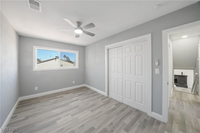 unfurnished bedroom with ceiling fan, light hardwood / wood-style floors, and a closet