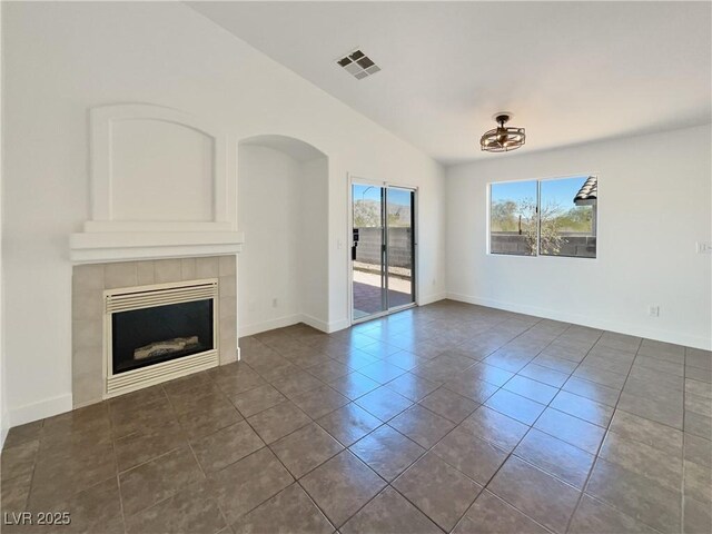 unfurnished living room with dark tile patterned floors and a tile fireplace