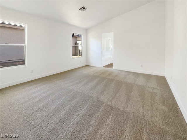 spare room featuring vaulted ceiling and carpet