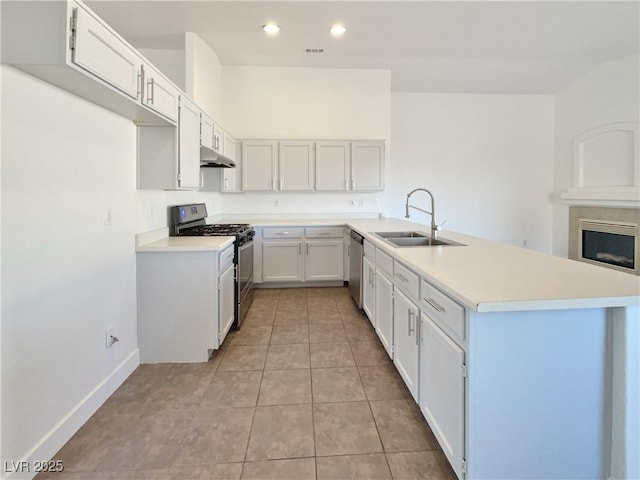 kitchen featuring stainless steel appliances, sink, white cabinets, light tile patterned floors, and kitchen peninsula