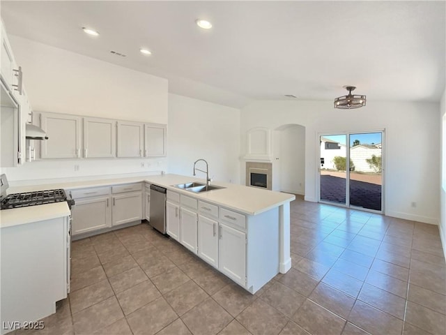 kitchen with stainless steel appliances, sink, white cabinetry, lofted ceiling, and kitchen peninsula