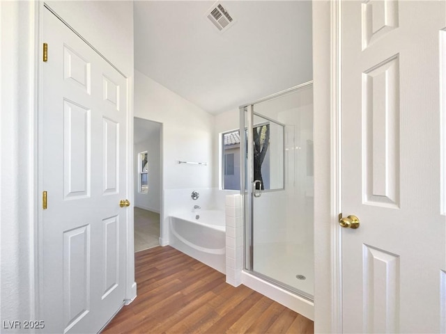 bathroom featuring separate shower and tub, vaulted ceiling, and wood-type flooring