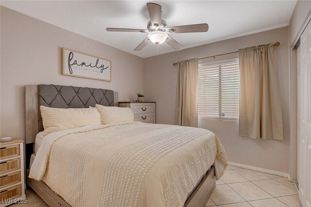 tiled bedroom with ceiling fan and a closet