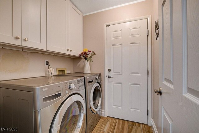 laundry area with light wood-type flooring, cabinets, ornamental molding, and washer and clothes dryer