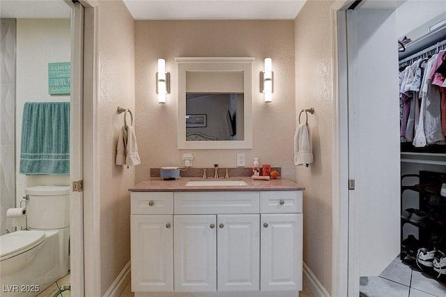 bathroom featuring tile patterned flooring, vanity, and toilet