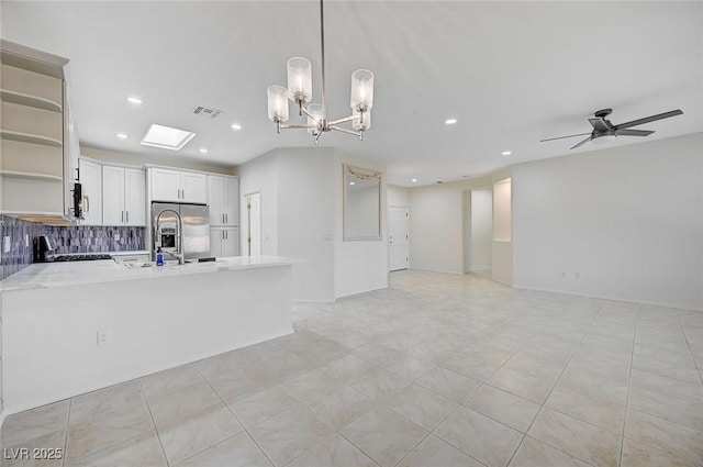 kitchen featuring hanging light fixtures, stainless steel appliances, ceiling fan with notable chandelier, white cabinets, and sink