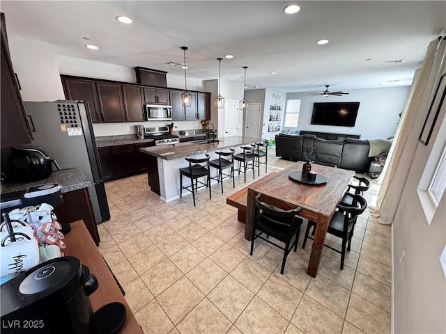 dining room with sink, light tile patterned flooring, ceiling fan, and plenty of natural light