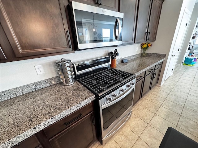 kitchen with light tile patterned flooring, dark brown cabinetry, and appliances with stainless steel finishes