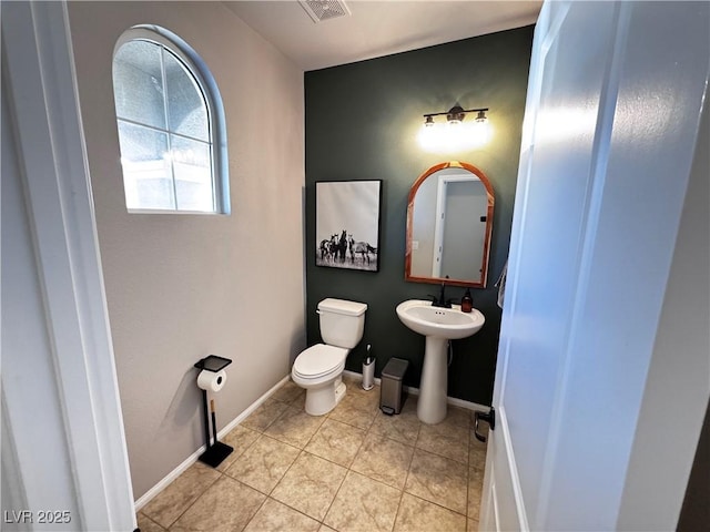 bathroom with toilet, tile patterned flooring, and sink