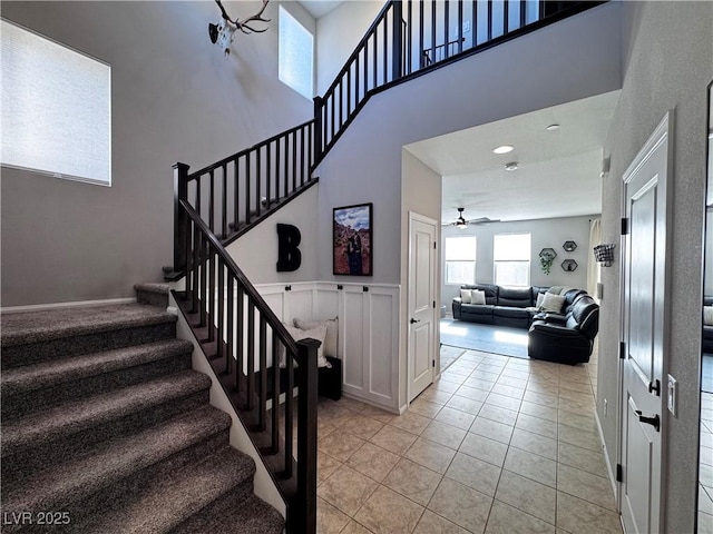 staircase with ceiling fan and tile patterned flooring