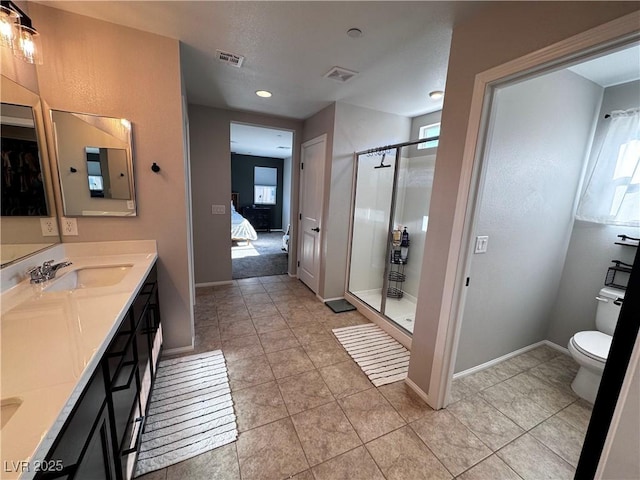 bathroom featuring tile patterned flooring, a shower with shower door, vanity, and toilet