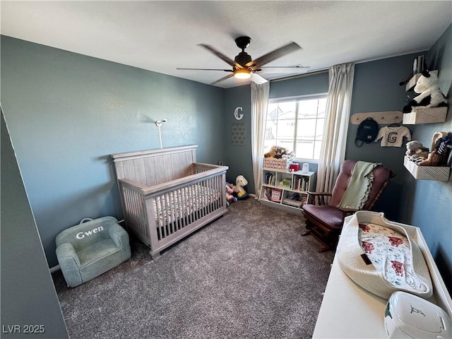 carpeted bedroom with a crib and ceiling fan