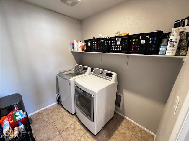 laundry area featuring light tile patterned flooring and washing machine and clothes dryer