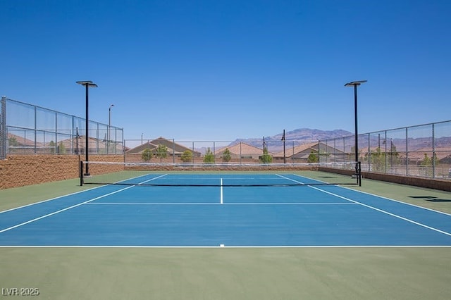 view of sport court featuring a mountain view and basketball hoop