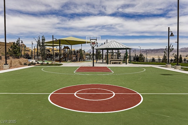 view of sport court featuring a playground, a mountain view, and a gazebo