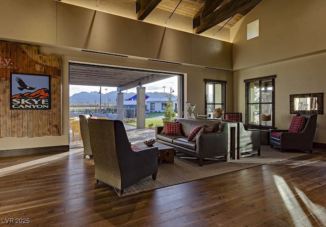 living room featuring beamed ceiling, dark wood-type flooring, high vaulted ceiling, and a mountain view