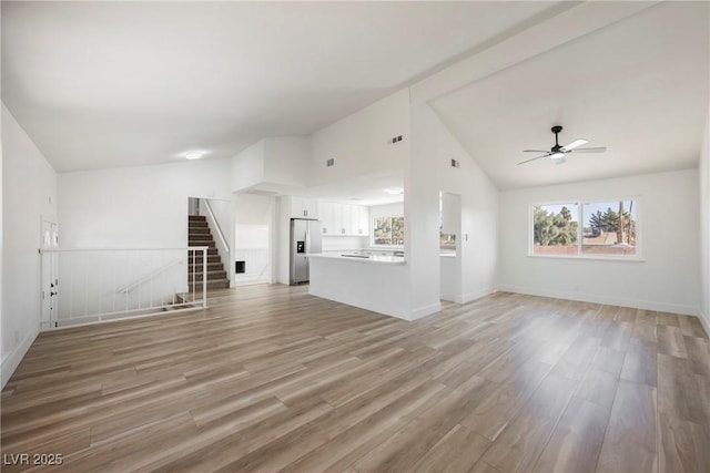 unfurnished living room featuring ceiling fan, light hardwood / wood-style floors, a brick fireplace, and high vaulted ceiling