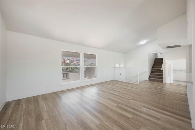 unfurnished living room with light hardwood / wood-style floors and vaulted ceiling