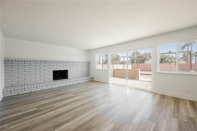 unfurnished living room with a fireplace and light hardwood / wood-style flooring