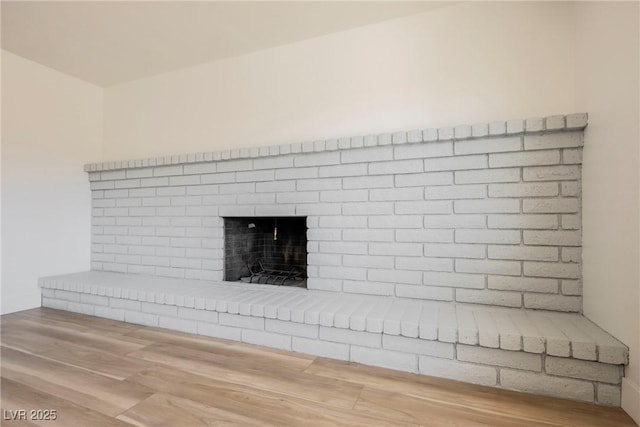 details featuring a brick fireplace and hardwood / wood-style floors