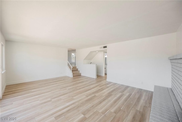 unfurnished living room with a fireplace and light hardwood / wood-style flooring