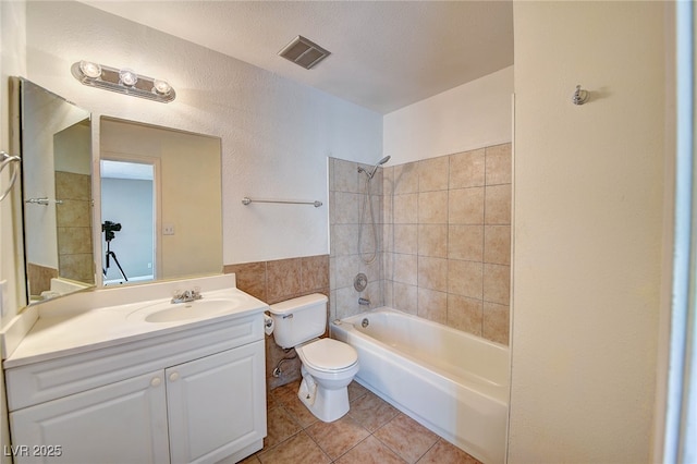 bathroom featuring visible vents, toilet, vanity,  shower combination, and tile patterned flooring