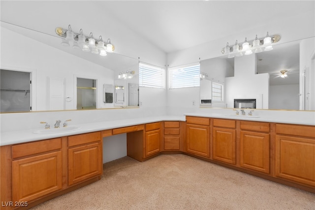 bathroom with ceiling fan, walk in shower, vaulted ceiling, and vanity