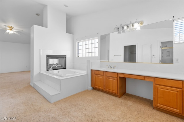 bathroom featuring ceiling fan, a bathtub, a towering ceiling, and vanity