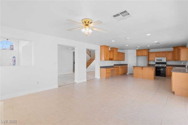 kitchen with sink, ceiling fan, light tile patterned floors, range, and a kitchen island