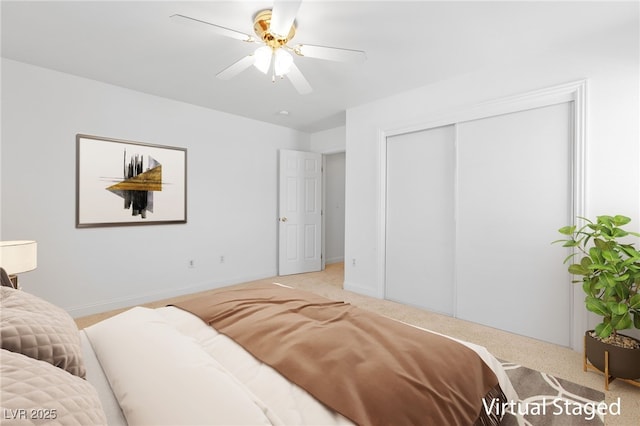 bedroom with ceiling fan, light colored carpet, and a closet