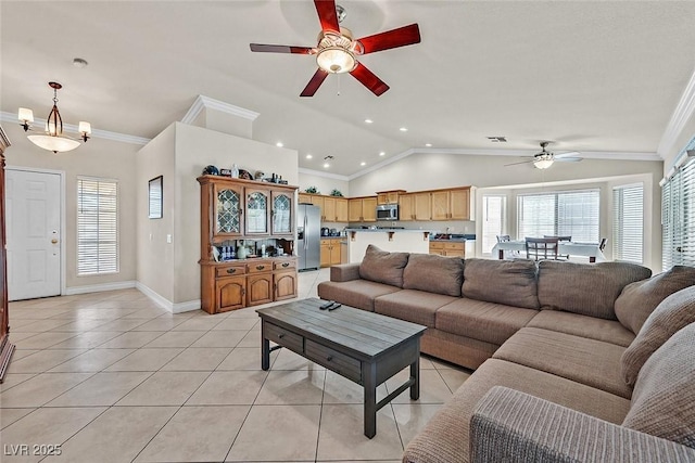 tiled living room with ceiling fan with notable chandelier, ornamental molding, and vaulted ceiling