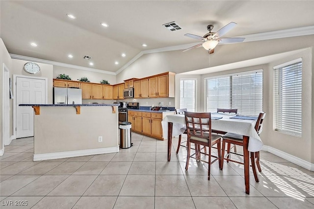 kitchen featuring vaulted ceiling, stainless steel appliances, a kitchen island, plenty of natural light, and ceiling fan