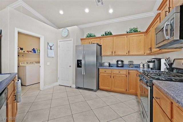 kitchen with vaulted ceiling, independent washer and dryer, stainless steel appliances, crown molding, and light tile patterned floors