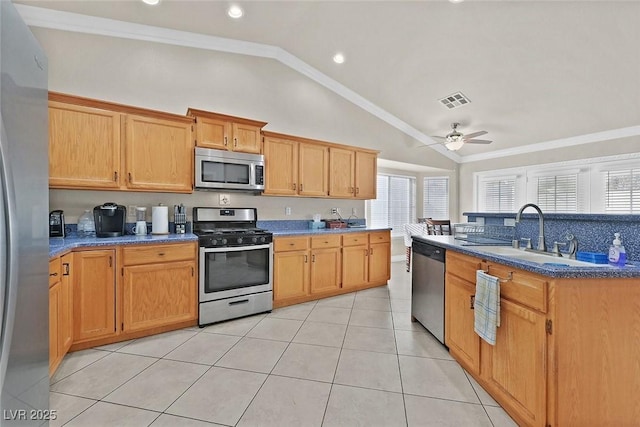 kitchen featuring stainless steel appliances, sink, lofted ceiling, light tile patterned flooring, and ceiling fan