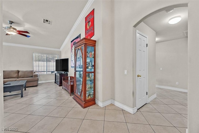 corridor featuring light tile patterned floors, vaulted ceiling, and crown molding