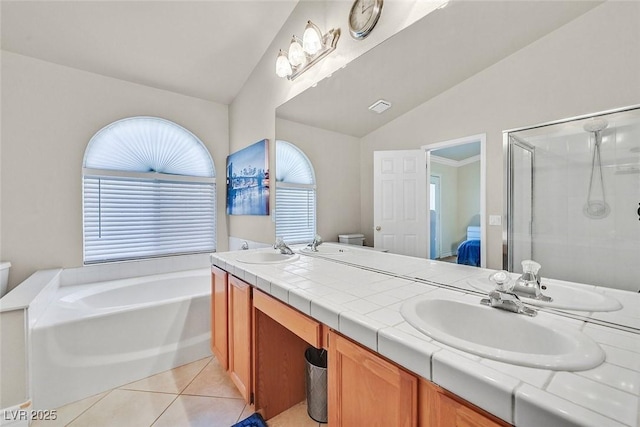 full bathroom with toilet, vaulted ceiling, tile patterned floors, separate shower and tub, and vanity